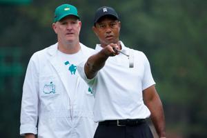 FILE - Tiger Woods talks with caddie Joe LaCava during a practice round of the 2022 Masters Tournament at Augusta National. LaCava recently threw his support behind Woods following his crash and arrest in Florida.