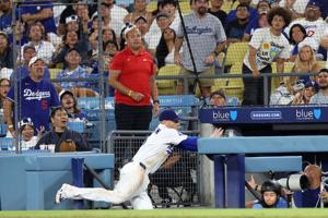 Los Angeles Dodgers first baseman Freddie Freeman (5) falls into the dugout while chasing a foul ball during the eighth inning against the Kansas City Royals at Dodger Stadium.