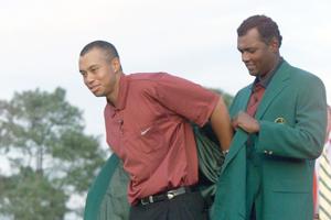 The 2000 Masters Champion, Vijay Singh, (r), helps the 2001 Masters Champion, Tiger Woods with the green jacket at the Masters