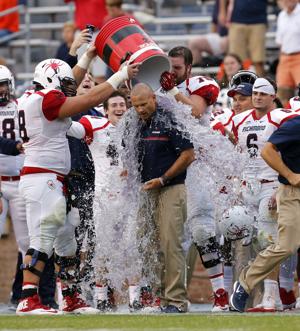 The University of Richmond's celebration of Saturday's 37-20 win at Virginia started with coach Danny Rocco getting doused by offensive linemen Thomas Evans and Patrick Kliebert. (Mark Gormus/Richmond Times-Dispatch)