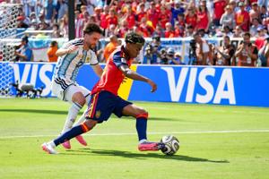 Spain forward Lamine Yamal (19) and Argentina defender Nicolás Tagliafico (3) battle for the ball during the FIFA World Cup