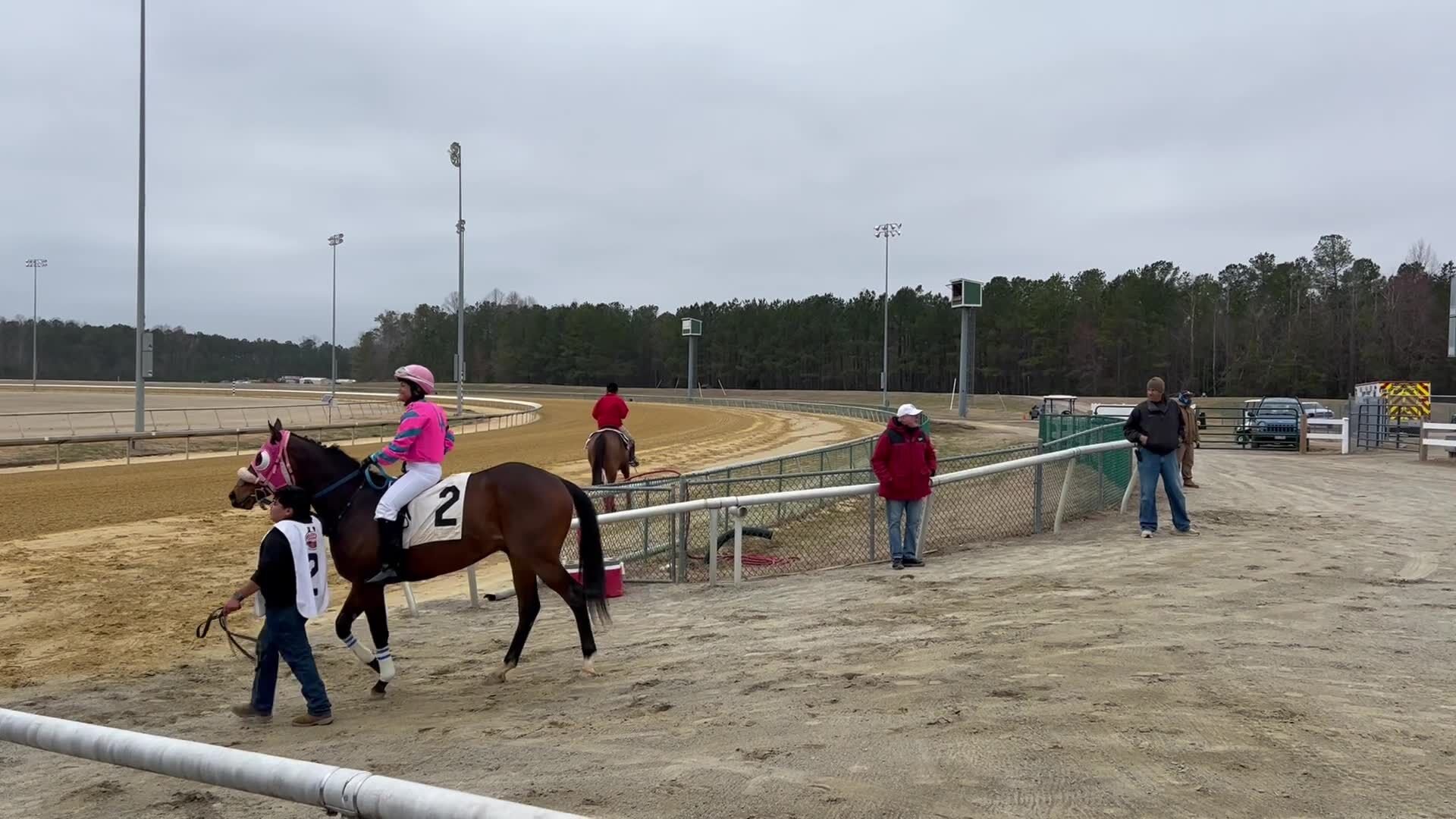 Horses exit the paddock enclosure and head toward the starting gate at Colonial Downs