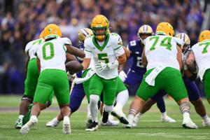 Nov 29, 2025; Seattle, Washington, USA; Oregon Ducks quarterback Dante Moore (5) hands the ball off to running back Jordon Davison (0) during the first half against the Washington Huskies at Husky Stadium. Mandatory Credit: Steven Bisig-Imagn Images