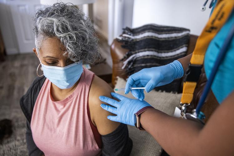 Black Nurse Giving Covid-19 Vaccine to Senior Black Woman