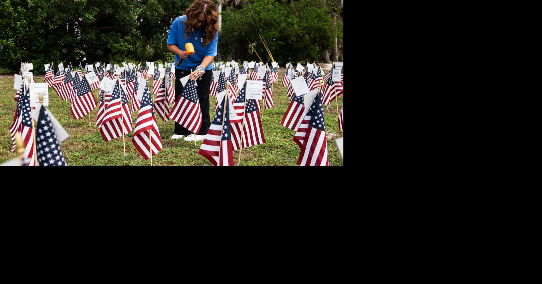 Denise Dillon, marketing and event coordinator for the City of Sanibel checks on and straightens the American flags honoring