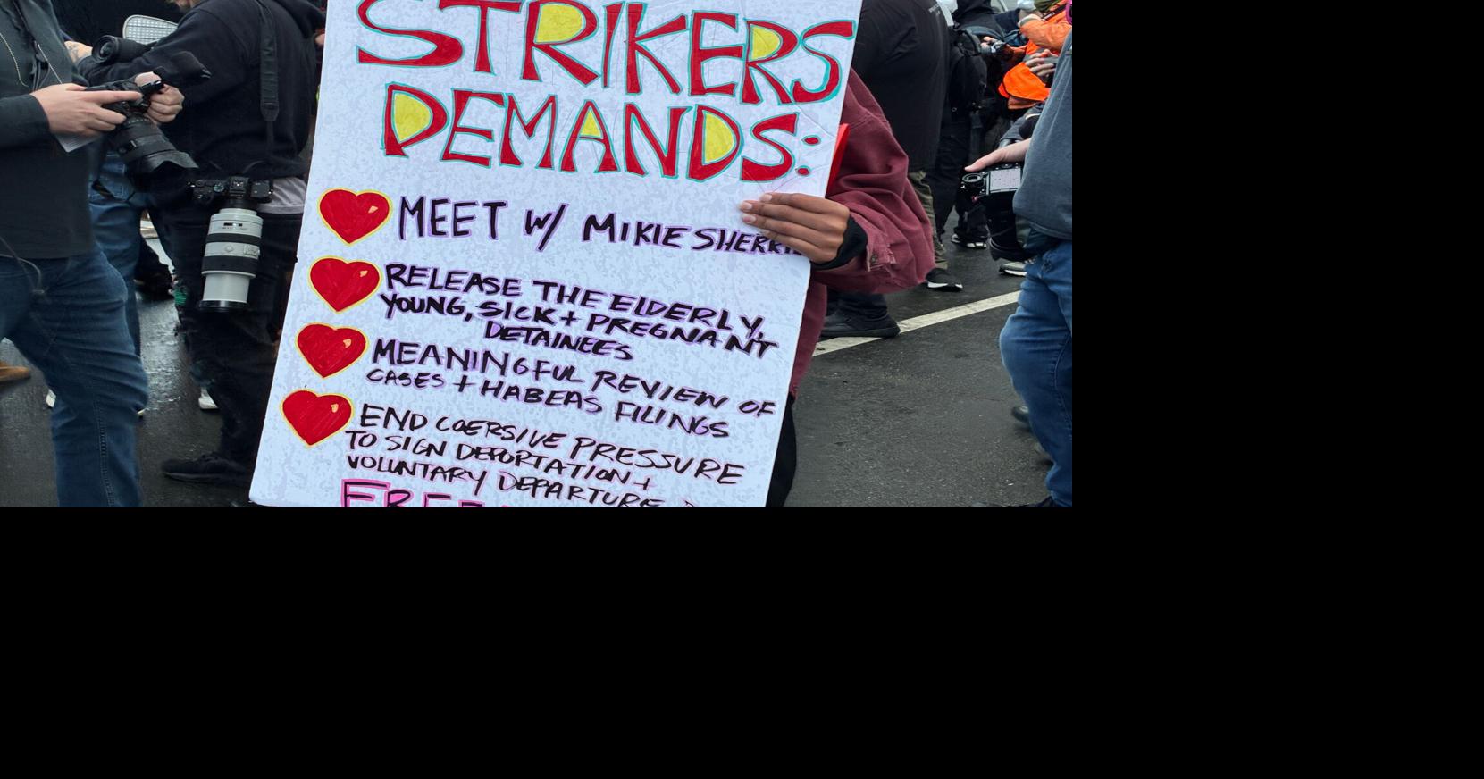 An anti-ICE protester outside Delaney Hall detention center in Newark on Saturday, May 30, 2026 holds a sign listing the demands of hunger strikers being held inside the facility.