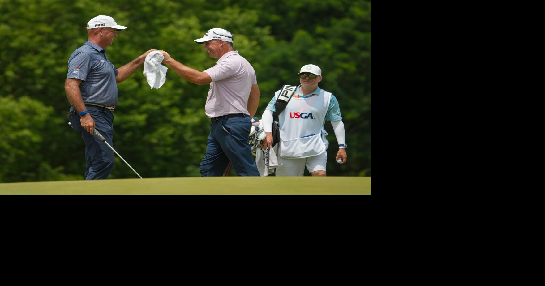 Stewart Cink gives Padraig a fist bump on the 14th green during the third round of the U.S. Senior Open at Scioto Country Club