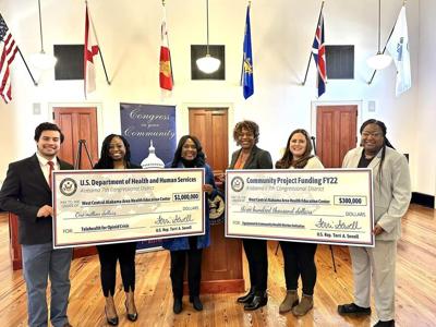 Sewell presents checks to the West Central Alabama Area Health Education Center