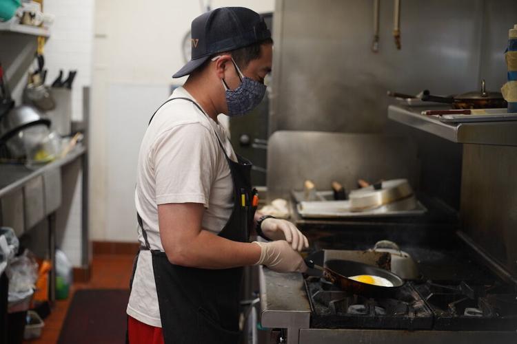 Store manager, Bobby Takahashi, prepares a fresh egg for a meal at Takahashi Market in San Mateo.JPG