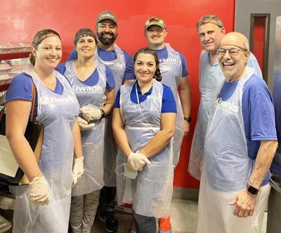 Members of the Kiwanis Club prepare for their monthly dinner service at Chapman Partnership. Air Force Captain Arnold Perez, third row center, heads up the meal service and reading programs for Kiwanis.