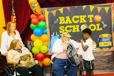 Palace Gardens residents Miguel Binelo and Esther Saavedra presented 9-year-old Zion Dean with a Google Chrome tablet and a supply-filled backpack