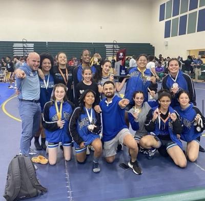 South Dade High School’s girl’s wrestling team celebrate with their coaches at states.