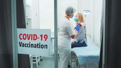Young woman getting coronavirus vaccine in hospital