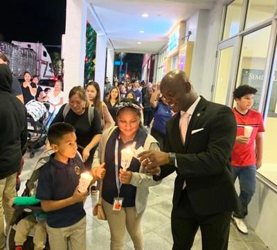 Miami-Dade Commissioner, District Nine Kionne McGhee was helping someone walking in the procession to relight their candle as they passed the Seminole Theatre.