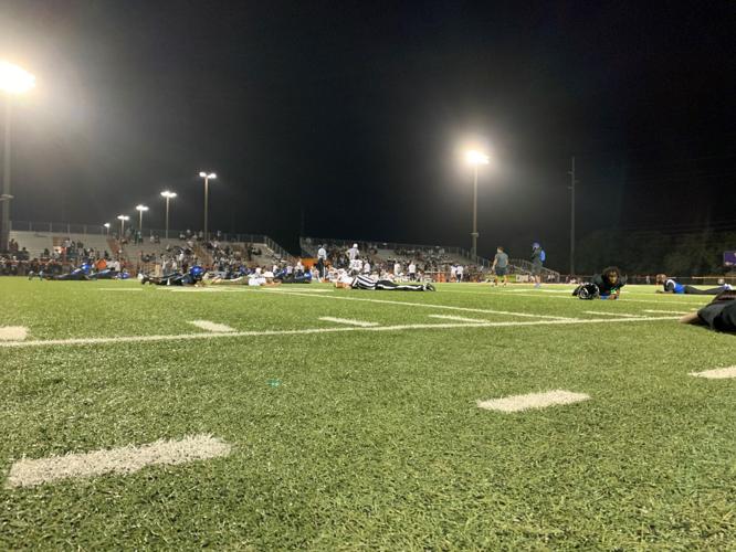 Players, coaches, officials and press lay flat on the field, as play was stopped in the fourth quarter after a fight in the stands caused a scare of a shooting.