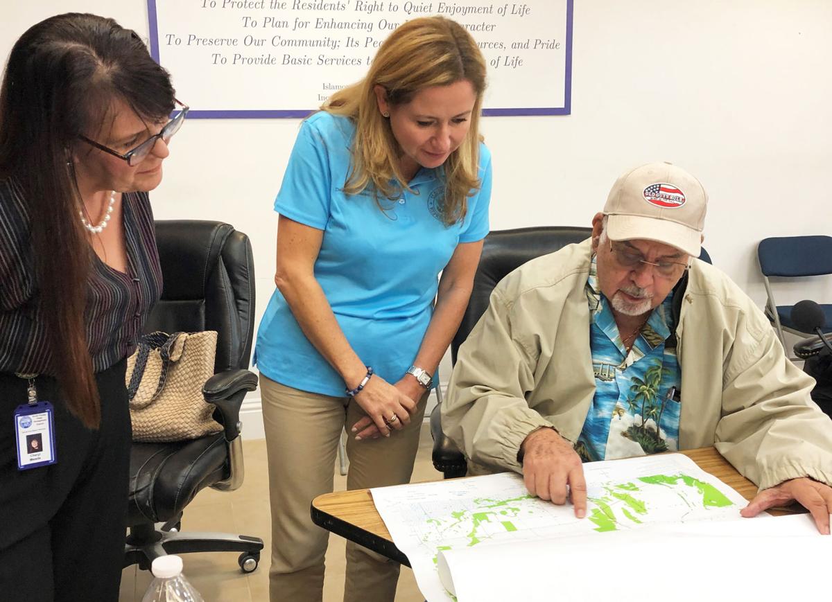 Bill Losner, of Redland, shows (from left) Cheryl Meads from the South Florida Water Management District and Rep. Debbie Mucarsel-Powell maps from  1953 and today, llustrating the impeadment of water flow into Flamingo.