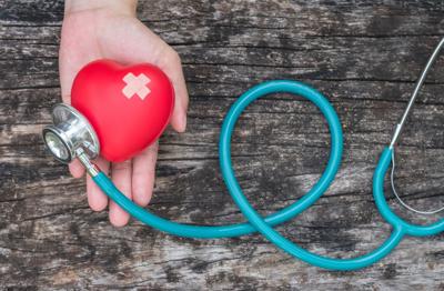 Healthcare insurance and World heart health day concept with red heart on woman's hands support with medical doctor's stethoscope