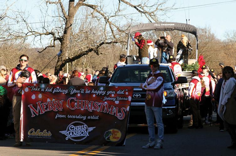 Country music singer-songwriter Chris Janson, grand marshal of the Leiper’s Fork Christmas Parade, prepares to pass out fishing rods and reels from a Cabela's Bass Pro Shop boat