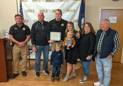 Sergeant Logan Curry with family and Sheriff Quire