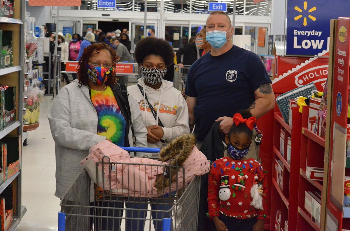 Iris Murdock (from left to right) Kamiah Murdock, Vinny Slavik, and Khalea Murdock pose for photo during the annual Cops and Kids shopping program sponsored by the Iredell County Fraternal Order of Police.
