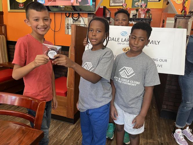 Benjamin Trivette receives a cookie from Boys & Girls Club members Yarheem and Ayden at Tacontento Mexican Restaurant in Statesville on Monday.