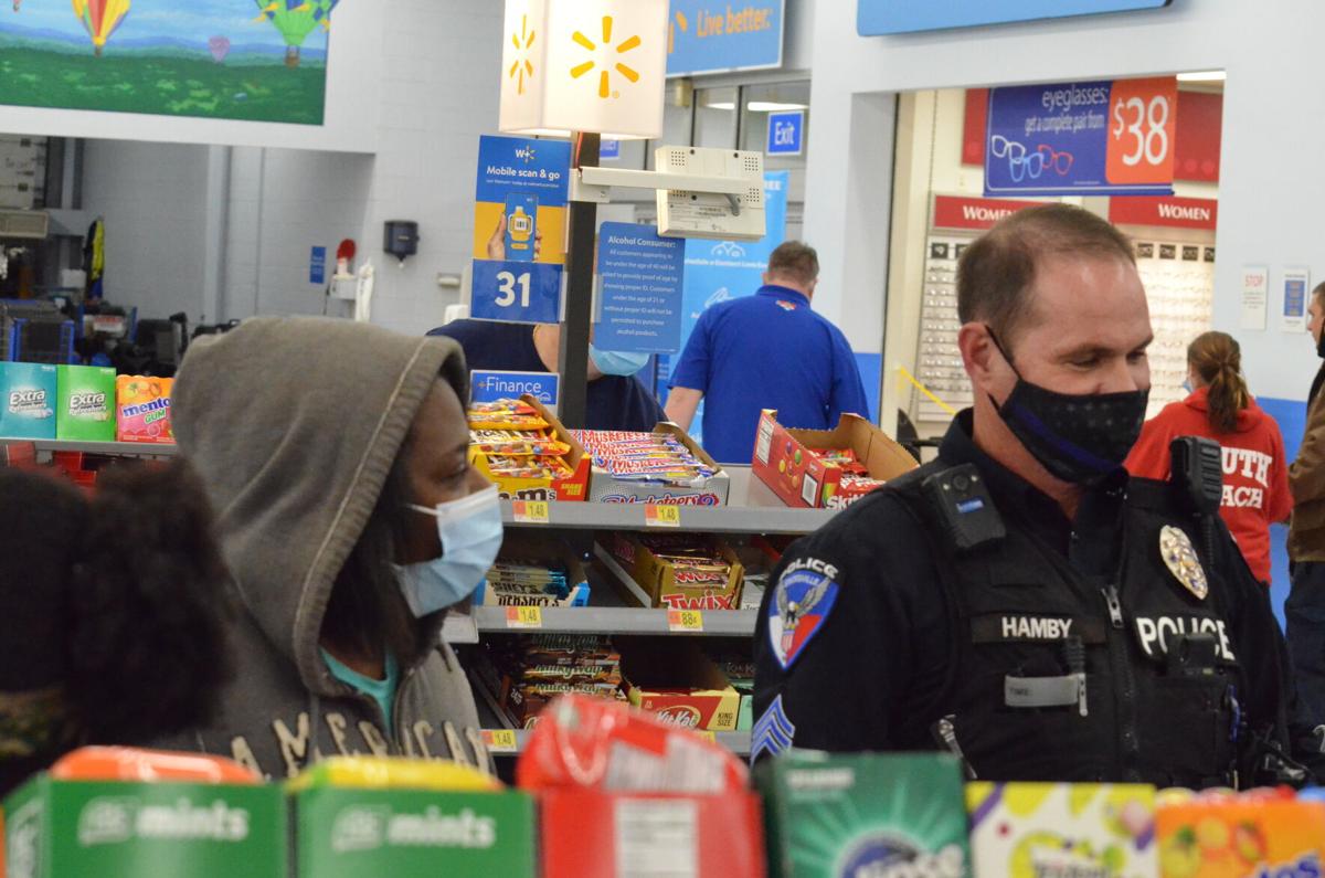 A Statesville Police officer chats with a woman as they check out during the annual Cops and Kids shopping program sponsored by the Iredell County Fraternal Order of Police.
