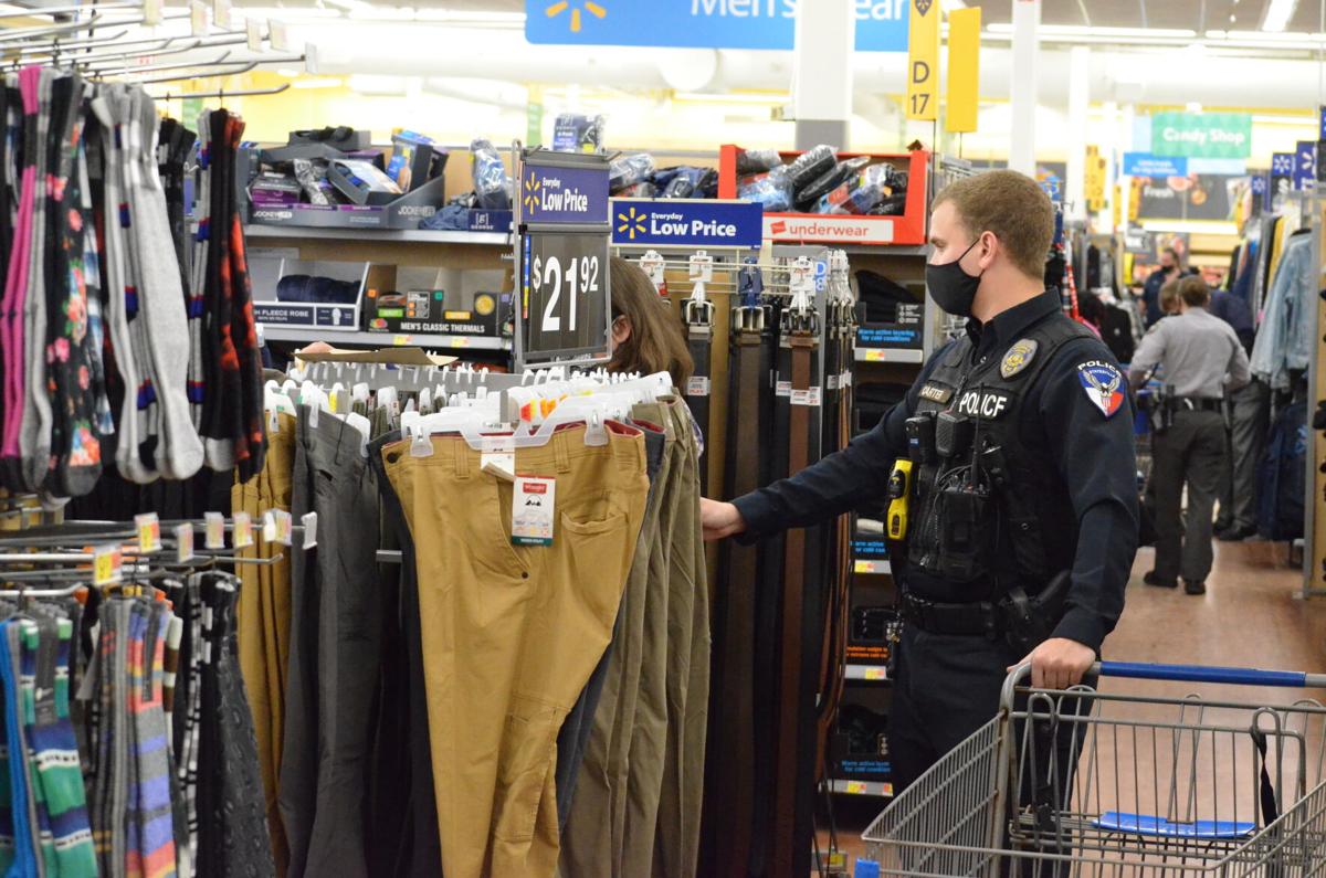 A Statesville Police officer helps a woman as she shops for clothes during the annual Cops and Kids shopping program sponsored by the Iredell County Fraternal Order of Police.