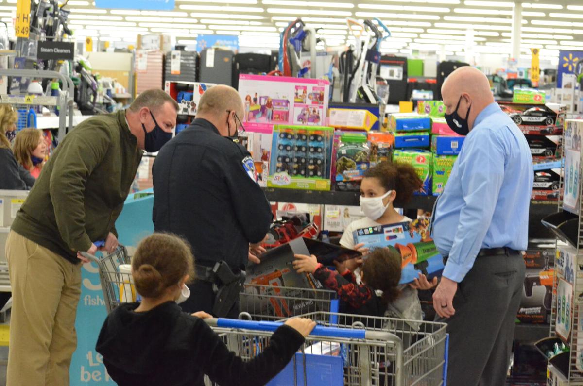Several members of law enforcement examine Nerf guns with children during the annual Cops and Kids shopping program sponsored by the Iredell County Fraternal Order of Police.