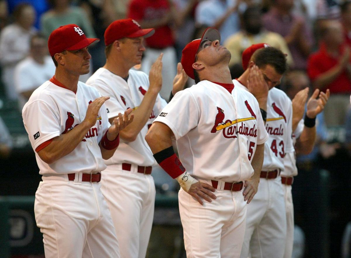 members of the St. Louis Cardinals stand for the National Anthem in their  1982 blue uniforms before a game against the Milwaukee Brewers at Busch  Stadium in St. Louis on August 5