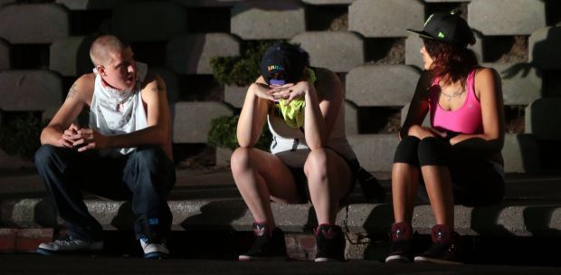 People sit after tear gas is fired