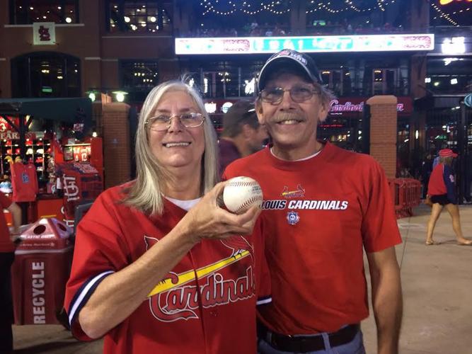 St. Louis Cardinals Aledmys Diaz retrieves a Jose Fernandez shirt that hung  in the dugout for their game against the Cincinnati Reds at Busch Stadium  in St. Louis on September 27, 2016.