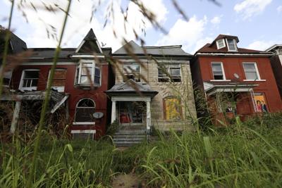 Uncut grass and weeds overwhelm vacant homes