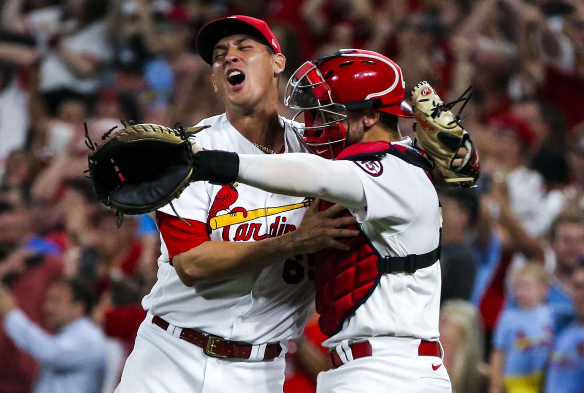 St. Louis Cardinals Harrison Bader removes his batting gloves after lining  out against the Detroit