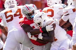 Ohio State Buckeyes defensive lineman Kayden McDonald (98) tackles Texas Longhorns running back CJ Baxter (4) during the NCAA football game at Ohio Stadium on Aug. 30, 2025.