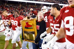Nov 22, 2025; Stanford, California, USA; Stanford Cardinal players take possession of the axe after the game against the California Golden Bears at Stanford Stadium. Mandatory Credit: Sergio Estrada-Imagn Images