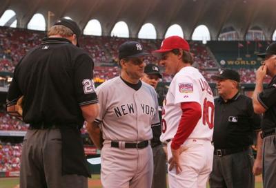 Joe Torre and Tony La Russa talk over lineup cards