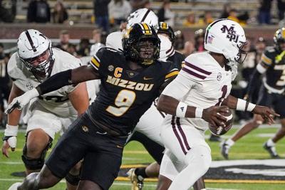 Nov 15, 2025; Columbia, Missouri, USA; Mississippi State Bulldogs quarterback Kamario Taylor (1) runs the ball as Missouri Tigers defensive end Zion Young (9) attempts the sack during the second half of the game at Faurot Field at Memorial Stadium. Mand...
