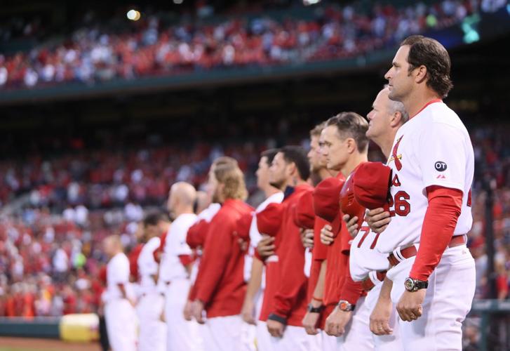 Several St. Louis Cardinals players stand for the National Anthem before a  game against the Milwaukee Brewers in high socks at Busch Stadium in St.  Louis on May 19, 2013. The team