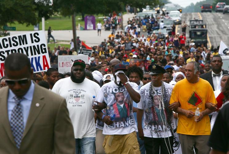 People gather on the anniversary of the fatal police shooting of Michael Brown
