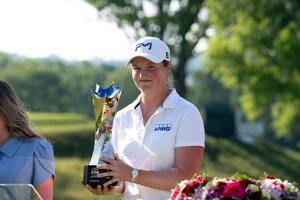 Lottie Woad, of Farnham, England, holds the trophy after winning the LPGA Kroger Queen City Championship fourth round at