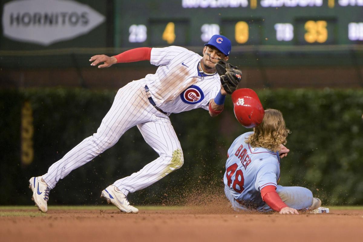 St. Louis Cardinals Harrison Bader makes a throw to first base in in an  attempt to get Chicago Cubs Willson Contreras trying to get back to the  base after a fly out
