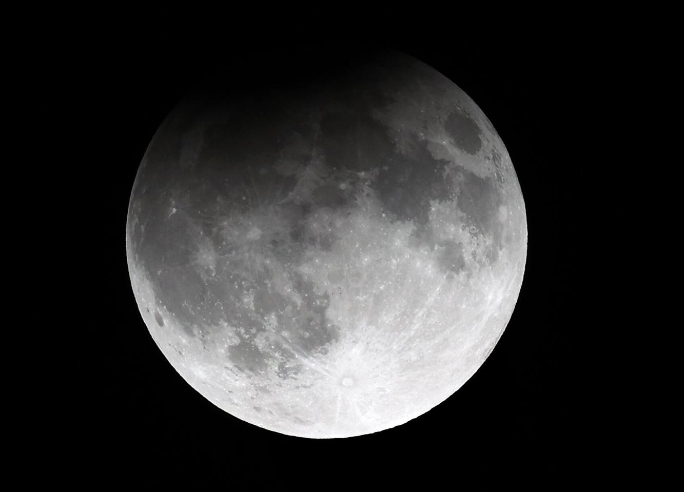 Rise of the harvest moon, with a partial lunar eclipse, glows over St