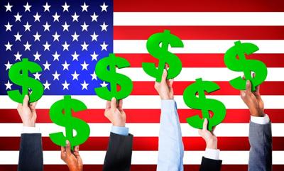 Multi-Ethnic Hands Holding Dollar Signs With Flag Of USA For The Background.