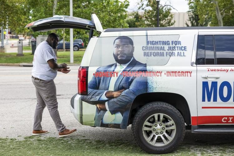 Alfred Montgomery collects campaign signs after upsetting St. Louis Sheriff Vernon Betts