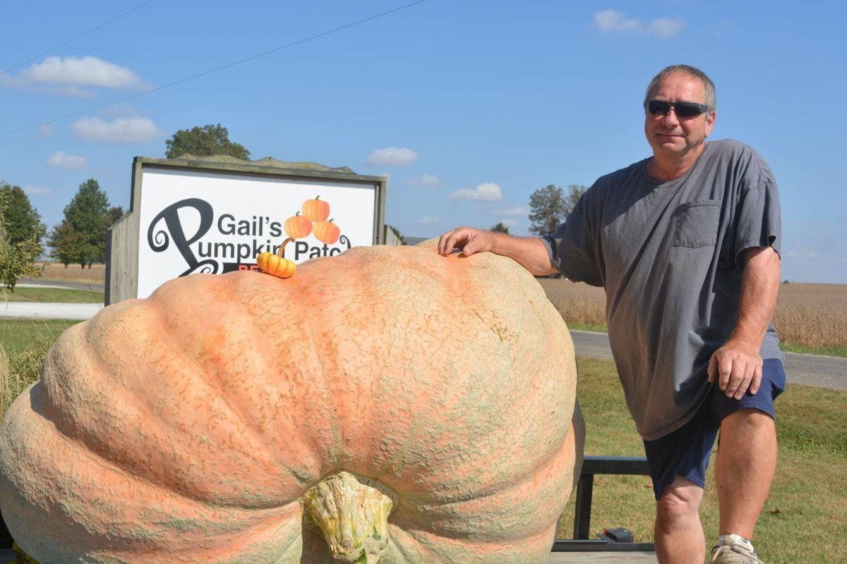 Henry Bartimus of DeWitt stands next to his 1,673-pound pumpkin, the largest grown in the state in 2020. He brought it to Gail's Pumpkin Patch in rural Beason on Sunday.