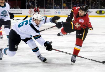 Stockton heat's Dillon Dube, right, shoots past San Jose Barracuda's Cavan Fitzgerald during an AHL hockey game at the Stockton