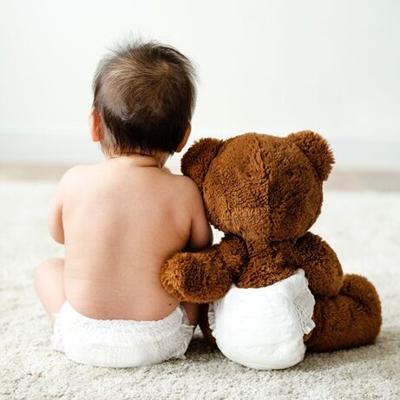 Back of a baby with a teddy bear