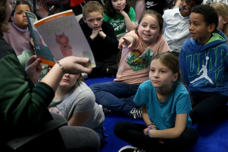 Senior reads to second grade class during Read Across Bayless event