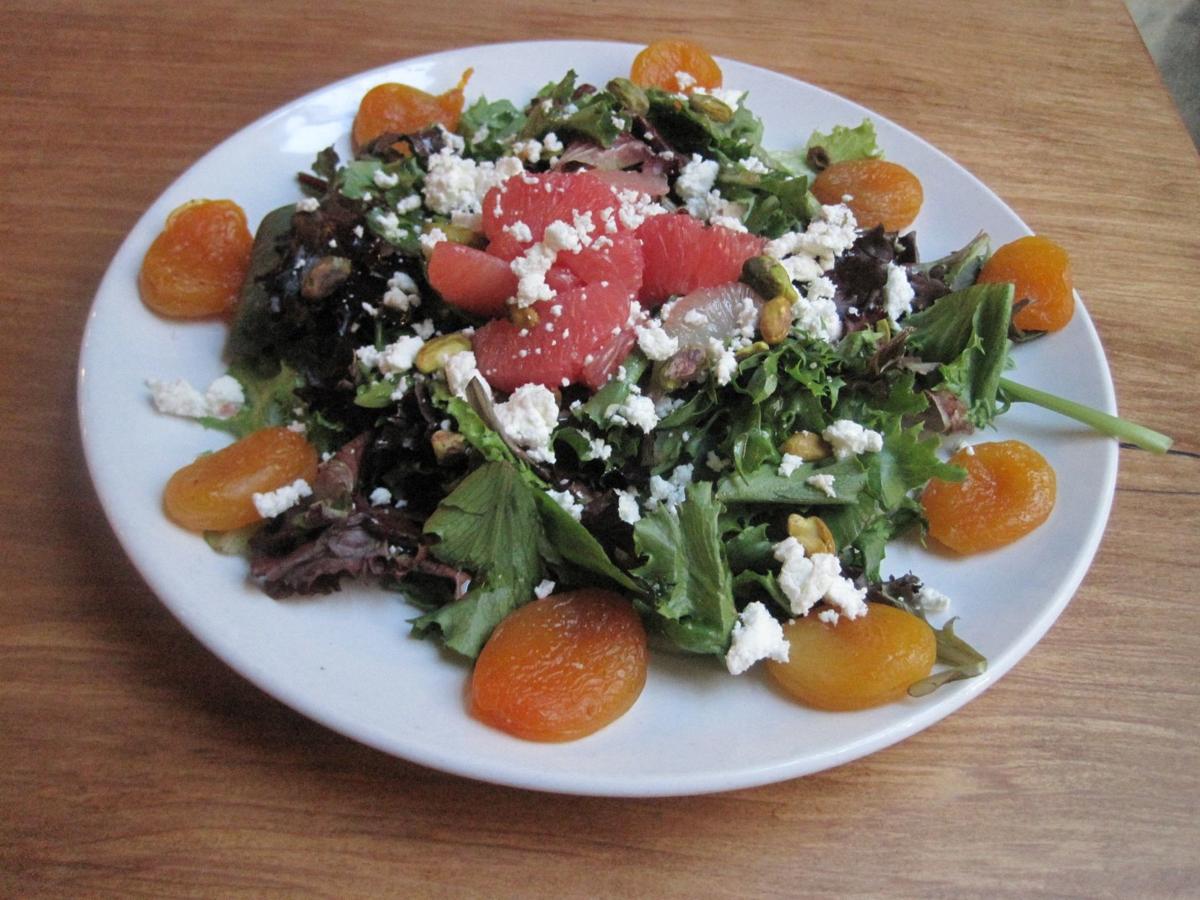 The full-size version of Grapefruit Salad at Bridge, pictured here, features the same ruby red grapefruit supremes, poached apricots, goat cheese, and chopped pistachios on a bed of sprightly greens dressed with a white balsamic vinaigrette as the smaller