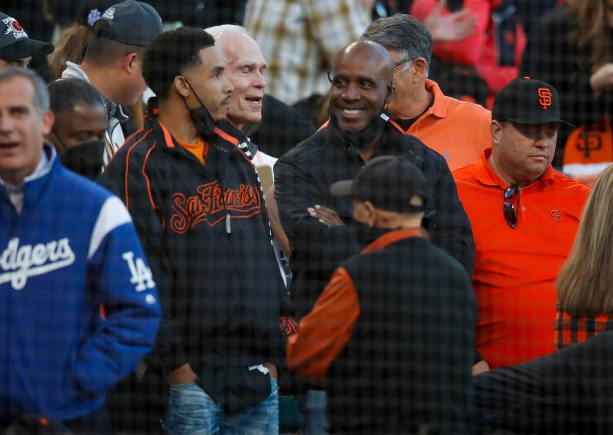 Former San Francisco Giants star Barry Bonds, middle right, smiles before the Giants play host to the Los Angeles Dodgers in Game 5 of the National League Division Series at Oracle Park on Oct. 14, 2021, in San Francisco.